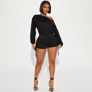 Close-up showing the ruched drawstring detail on a black one-shoulder long sleeve romper