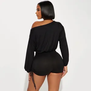 Back view of a black off-shoulder long sleeve romper with ruched drawstring detail