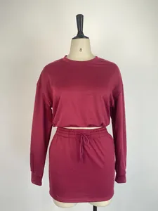 Detailed view of women's two-piece burgundy set with long sleeve top and bodycon skirt