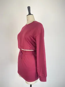 Side view detail of women's magenta two-piece set with long sleeve top and mini skirt