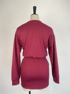 Back view of a women's solid color two-piece set with long sleeve top and mini skirt