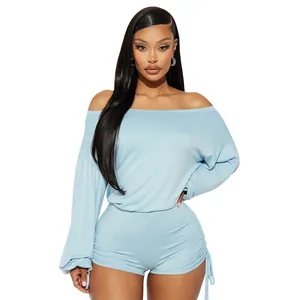 Detail of light blue off-the-shoulder romper featuring ruched sides and drawstring sleeves.