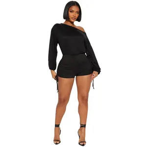 Detail view of a black off-the-shoulder long sleeve ruched drawstring romper