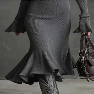 Détail d'une élégante robe sirène en tricot avec des manches évasées et un ourlet volanté.