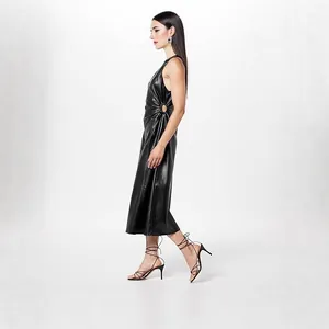 Detailed side view of a black PU leather dress featuring waist gathers and ring detail.