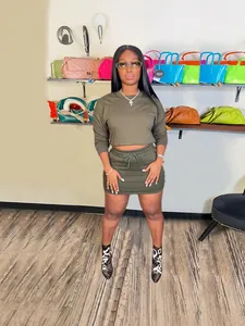 Two-piece olive green outfit featuring long sleeve crop top and bodycon mini skirt set.