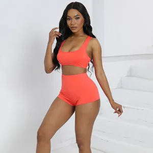 Donna che indossa un set moda arancione vivace con crop top e pantaloncini a vita alta