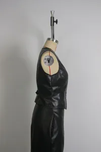 Dettaglio del profilo laterale di un gilet nero in finta pelle con scollo a V su manichino