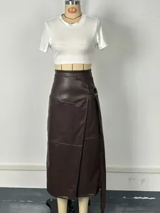 Macro detail of a dark brown PU leather A-line skirt with an asymmetric adjustable belt