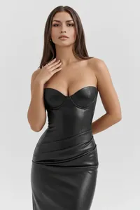 Modella che indossa un tubino a fascia in ecopelle nera con eleganti dettagli arricciati.