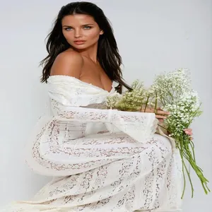 Close-up detail of elegant white off-the-shoulder lace dress with flared sleeves and slim fit