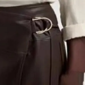 Elegant PU leather A-line skirt featuring asymmetrical wrap waist and metal buckle detail.