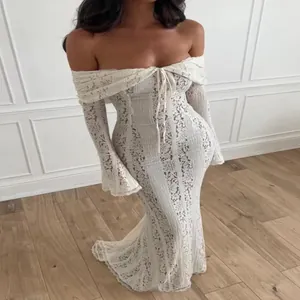 Detail view of white lace hollow-out off-the-shoulder maxi dress with bell sleeves.