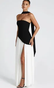 Detail view of a black and white strapless evening dress with side split and neck ribbon.