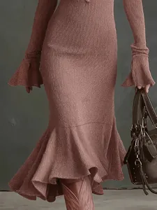 Détail d'une robe sirène en maille vieux rose avec manches évasées et ourlet plissé élégant
