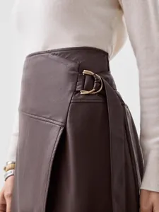 Elegant brown PU leather A-line long skirt featuring adjustable belt and irregular split design