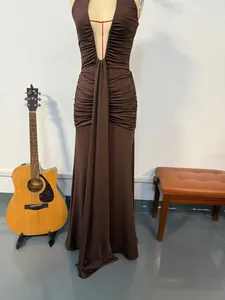 Dettaglio elegante dell'abito lungo marrone con scollo a V profondo e ruches all'americana