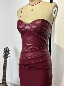 Vista dettagliata del vestito aderente sexy in ecopelle bordeaux con balze eleganti.