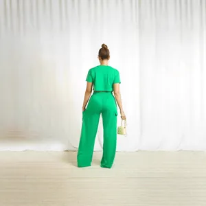Back view of women's bright green two-piece set featuring short sleeve crop top and cargo pants