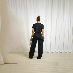 Back view of a chic black two-piece set featuring a short-sleeve crop top and wide-leg cargo pants.