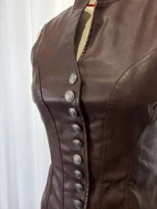 Close-up of brown PU leather vest with decorative silver buttons and corset seams