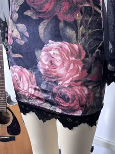 Close-up detail of sexy rose floral print dress with delicate black lace hemline