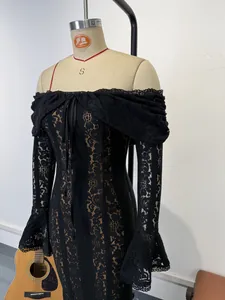 Detail view of a black lace off-shoulder dress with flare sleeves on a mannequin