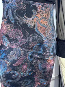 Detail shot of sexy mesh patchwork dress with vibrant paisley print and slim fit design.