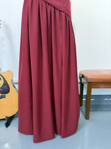 Close-up of the elegant burgundy high-slit gown with pleated fabric details