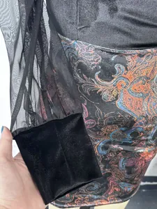 Close-up detail of sheer black mesh sleeve and velvet cuff on printed bodycon dress