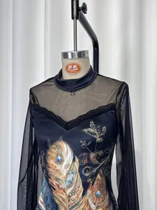 Detail view of a black mesh dress with elegant feather print and lace trim detailing