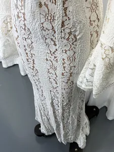 Close-up detail of white lace hollow-out off-shoulder maxi dress with flare sleeves