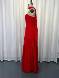 Side view of a red strapless evening dress with elegant halter neck ribbon detail.