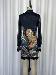 Rear detail of printed mesh dress with lace cuffs and hem displayed on a mannequin