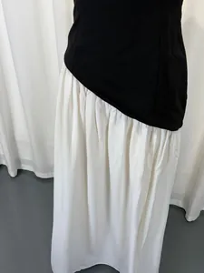 Close-up of elegant black and white color block strapless dress with pleated skirt