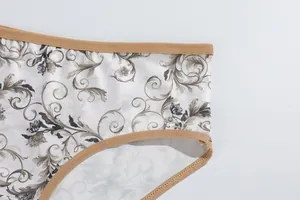 Detailed macro view of floral print milk silk women's panties with brown elastic trim
