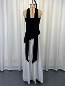 Back view of elegant halter neck dress with long black hanging straps and white skirt