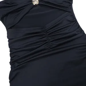 Gros plan sur un tissu noir froncé avec une boucle décorative en métal doré
