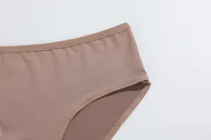 Detailopname van de gladde zachte stof van damesonderbroeken in nude huidskleur