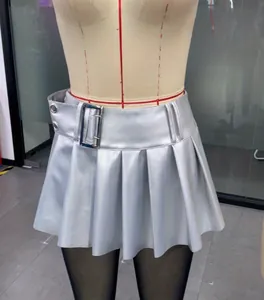 Detail of a silver metallic pleated mini skirt with a wide punk style belt and buckle.