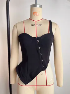 Close-up van een zwarte one-shoulder corset top met haaksluiting en onregelmatige zoom