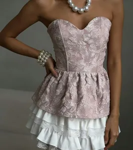 Detail van roze gebloemde jacquard strapless top met een witte kanten ruisrand aan de zoom