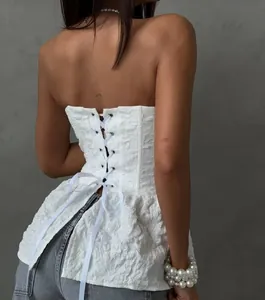 Achterdetail van een witte jacquard korset-top met een verstelbare vetersluiting