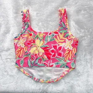 Dettaglio di crop top con stampa floreale tropicale rosa, spalline larghe e orlo curvo