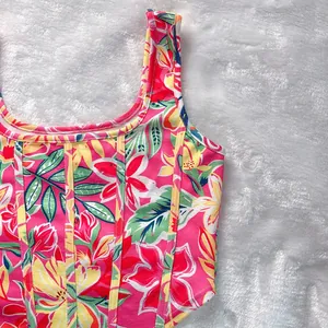 Dettaglio di un crop top a fiori con cuciture stile corsetto di supporto per l'estate.