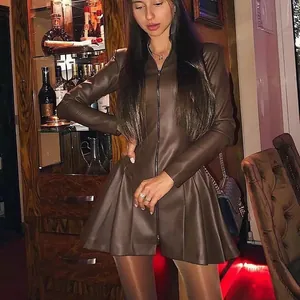 Detail view of a stylish brown PU leather long sleeve pleated mini dress with zipper.