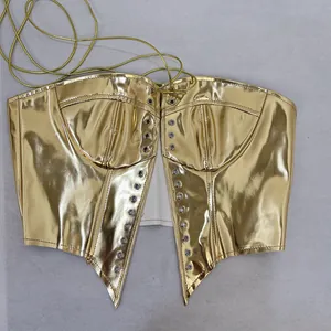 Détail du haut bustier doré métallisé avec laçage et œillets brillants