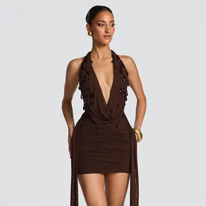 Elegant detail of a brown halter bodycon dress with deep V-neck and beaded teardrop accents