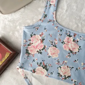 Dettaglio ravvicinato di un crop top blu chiaro con stampa floreale rosa su tappeto