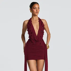 Detailed view of burgundy halter mini dress with deep V-neck and teardrop embellishments
